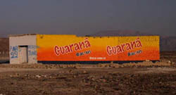 Orange soda advertised on the side of an abandoned building